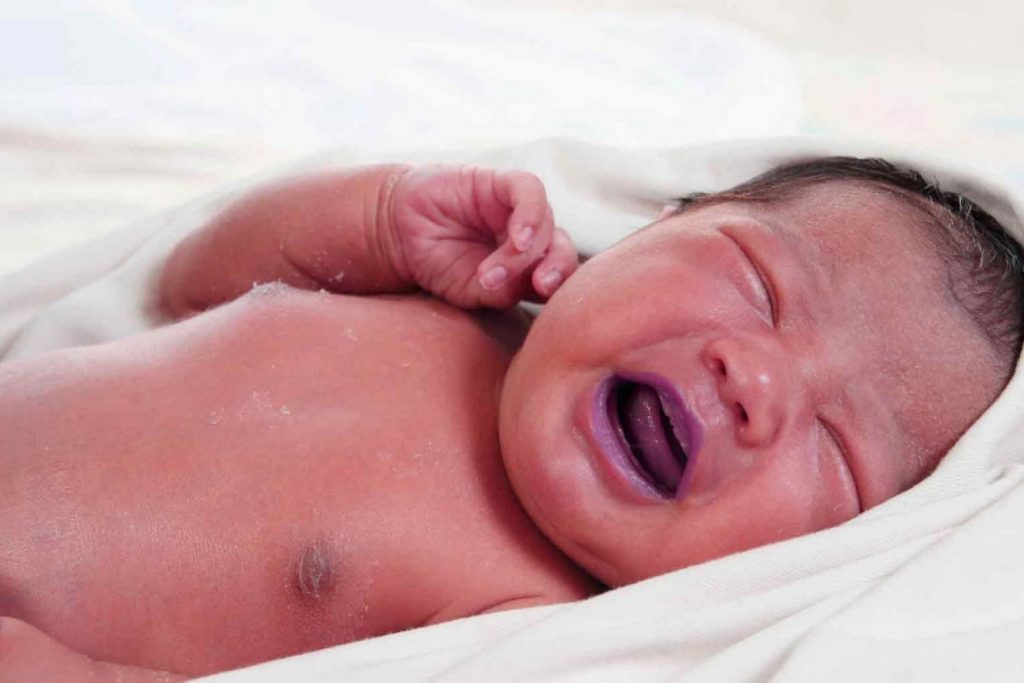 Un bebé recién nacido con los ojos cerrados y envuelto en una manta. La foto acompaña la noticia sobre el original nombre Chat Yipiti en Colombia.