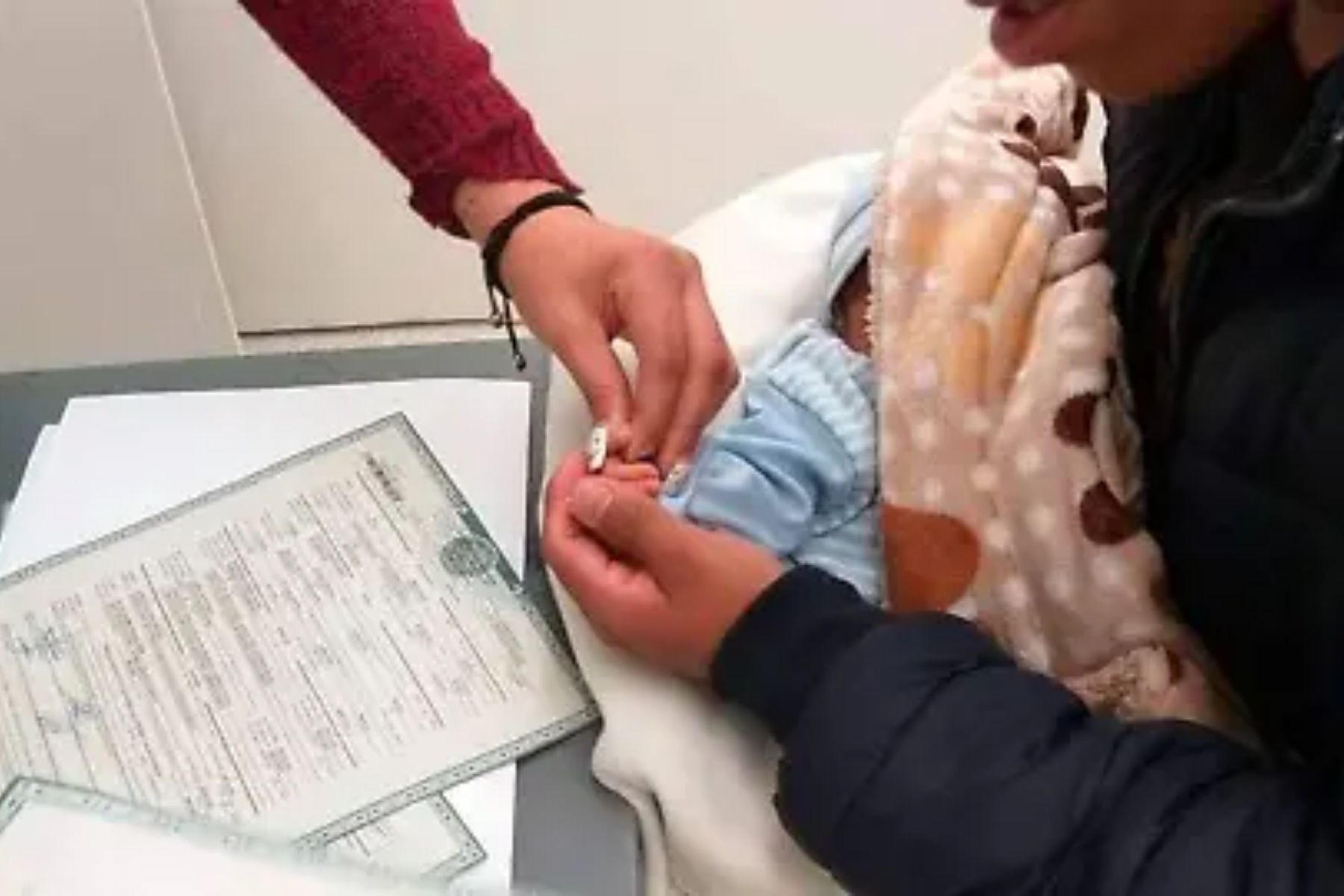Proceso de registro de un bebé en una oficina del registro civil. La imagen ilustra la noticia de la niña nombrada Chat Yipiti en Colombia.
