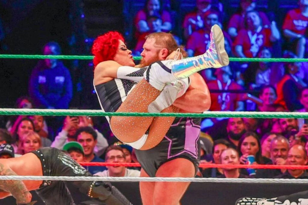 El luchador Pimpinela Escarlata aplicando una llave a su oponente en el ring. La nota habla sobre su estilo de lucha único que impresionó a directivos de WWE.
