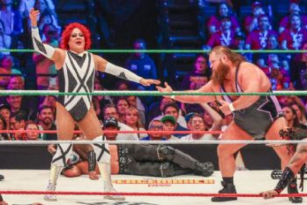 El luchador Pimpinela Escarlata interactuando con un rival en el ring. La nota destaca el carisma del personaje, clave en la anécdota con Triple H.