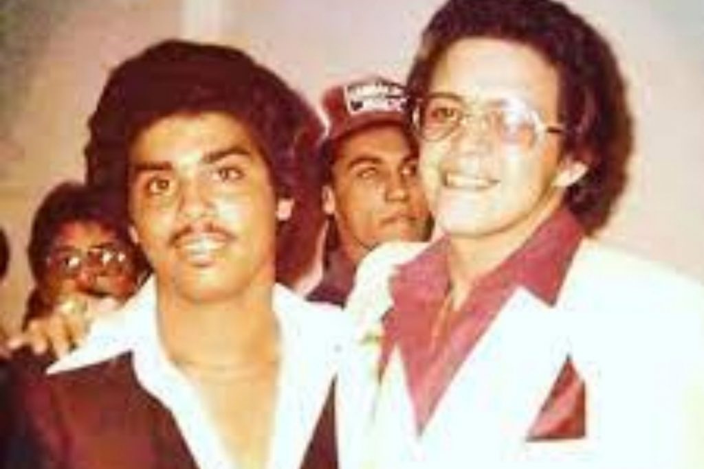 Un joven Gilberto Santa Rosa posando junto a Héctor Lavoe en sus inicios. La nota explora las colaboraciones y amistades que forjó en su carrera musical.
