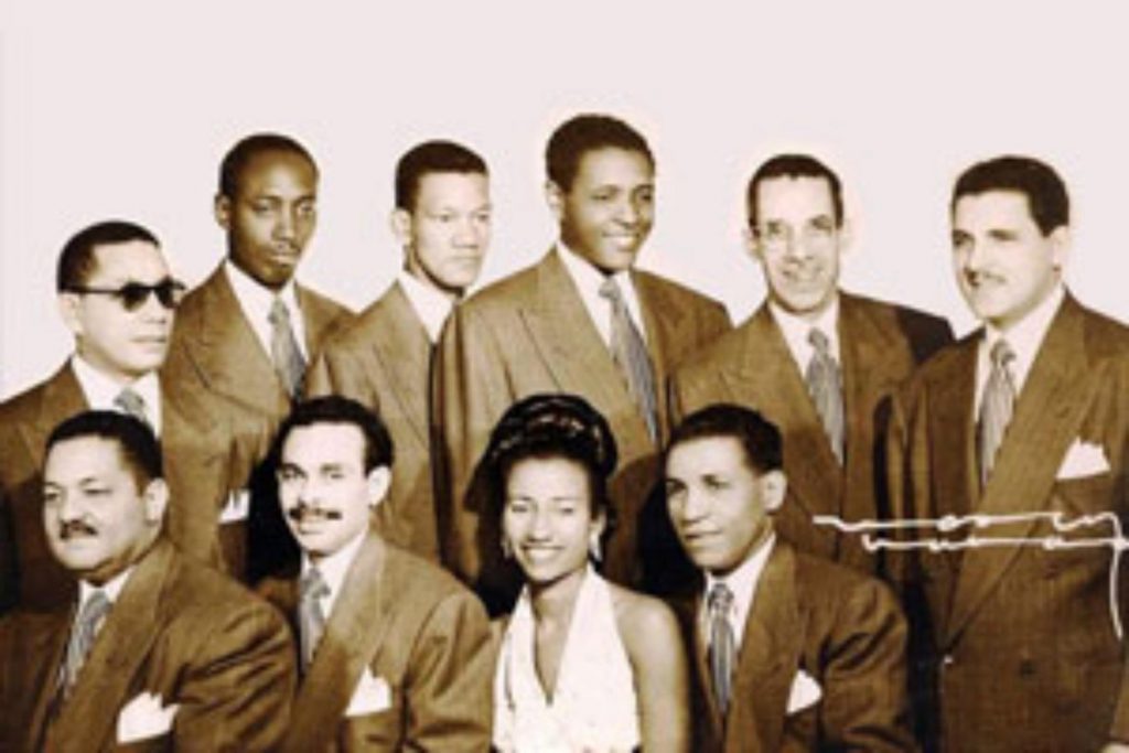 La cantante Celia Cruz junto a los músicos de la Sonora Matancera en sus primeros años juntos. La nota recuerda la etapa que catapultó a la fama a "La Reina de la Salsa".