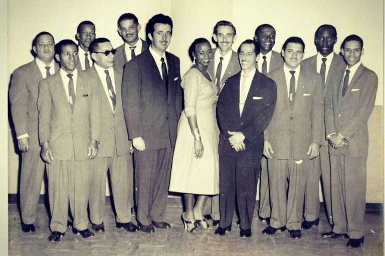 La legendaria Sonora Matancera junto a la cantante Celia Cruz en una foto de época. La nota celebra la historia de la agrupación y sus grandes éxitos.