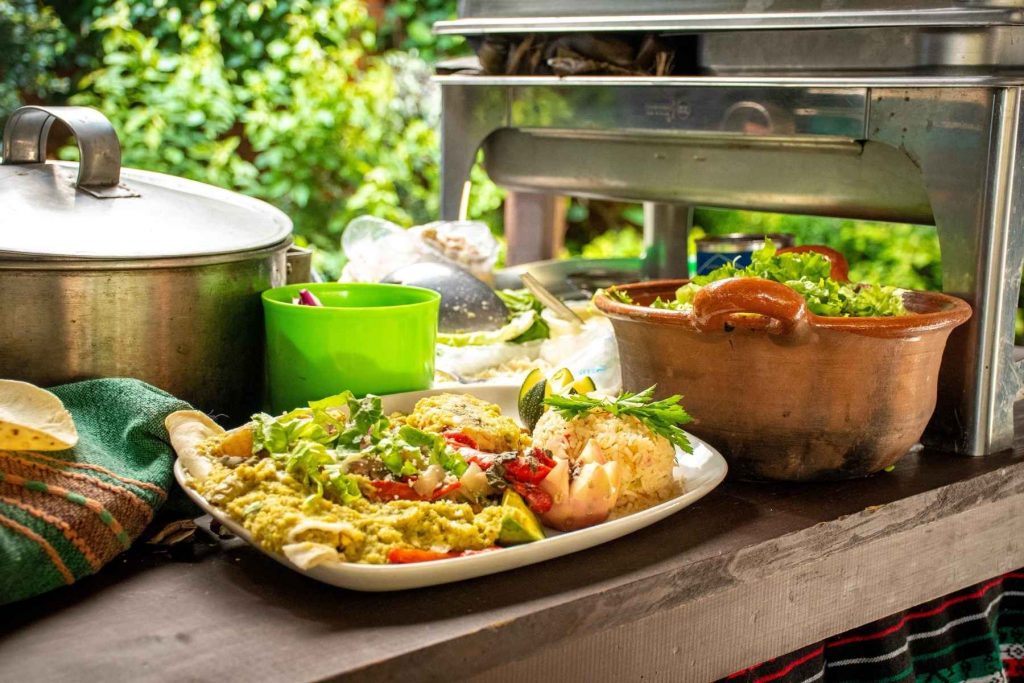 Un plato de enchiladas "Arrieras" acompañadas de cecina y arroz. La nota informa sobre la Feria de la Enchilada, un evento para toda la familia en Iztapalapa.