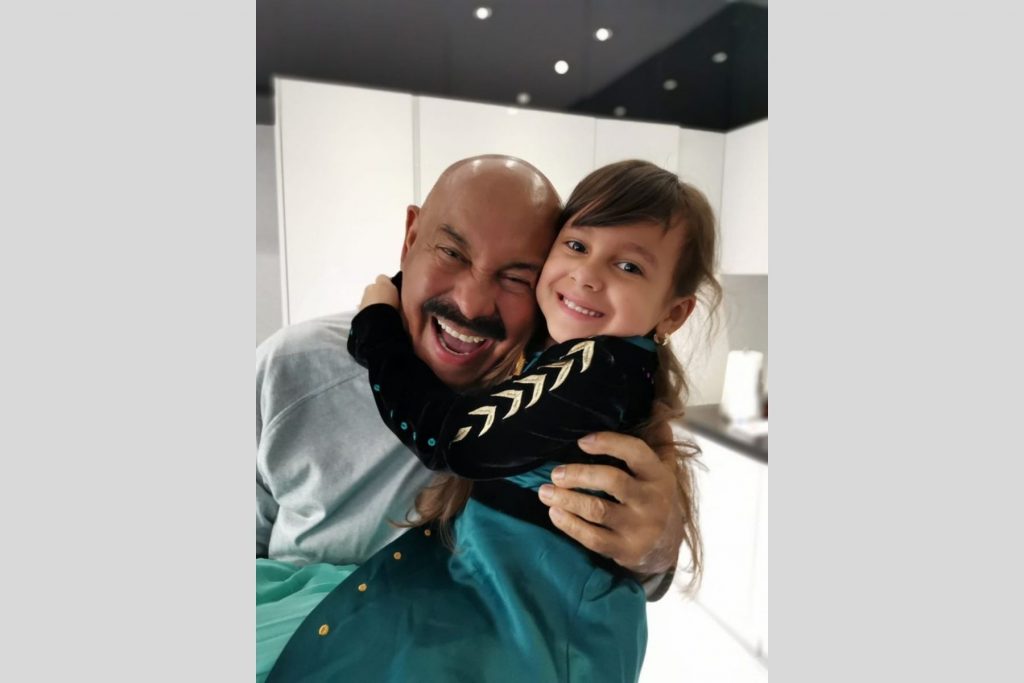 El cantante de salsa Oscar de León abrazando a su nieta