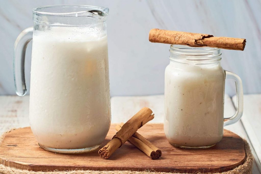 Una jarra de agua de horchata casera, que representa el color blanco de la bandera. La nota comparte la receta tradicional para que te quede cremosa y deliciosa para la fiesta.