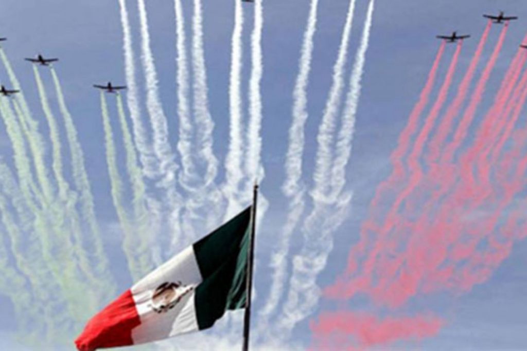 Aviones de la Fuerza Aérea Mexicana pintando el cielo con los colores patrios. La nota explica el significado del espectáculo aéreo en el Desfile Militar.