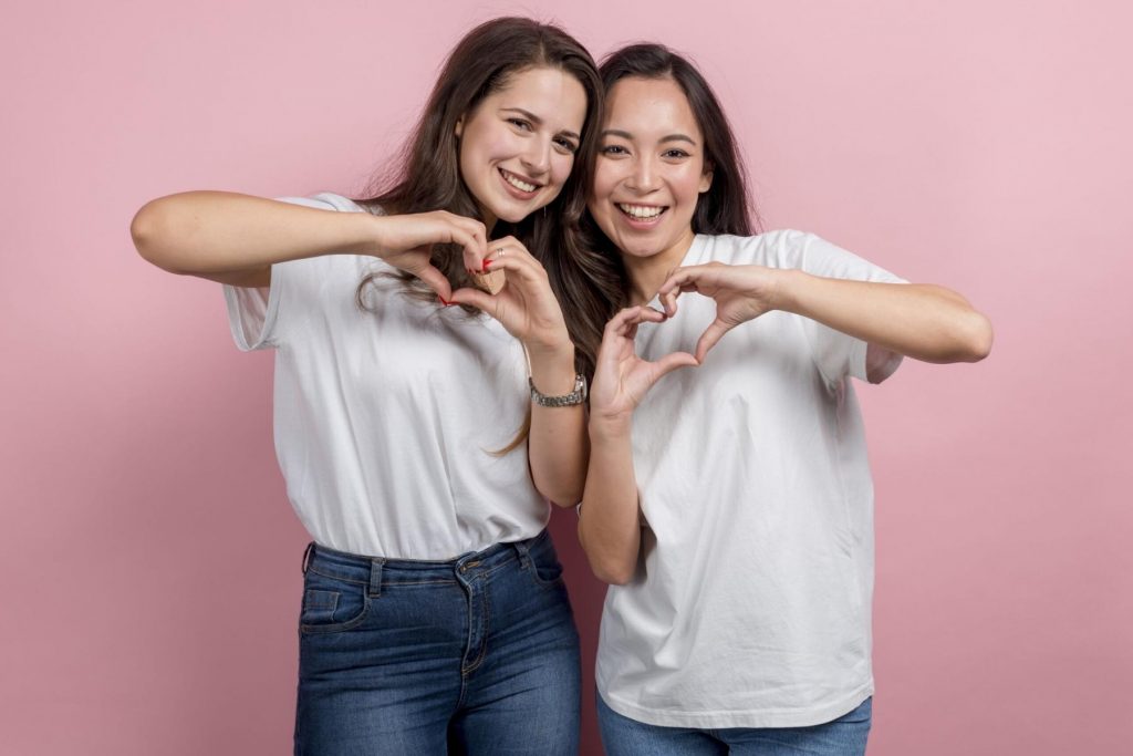 Dos amigas sonriendo y formando un corazón con sus manos. La nota habla sobre las señales de una amistad verdadera y cómo reconocer a una amiga leal.