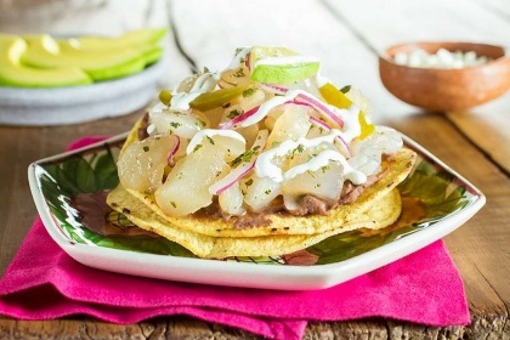 Unas deliciosas tostadas de pata de res encurtida, un antojito clásico para la Noche Mexicana. La nota ofrece recetas fáciles y económicas para el 15 de septiembre.