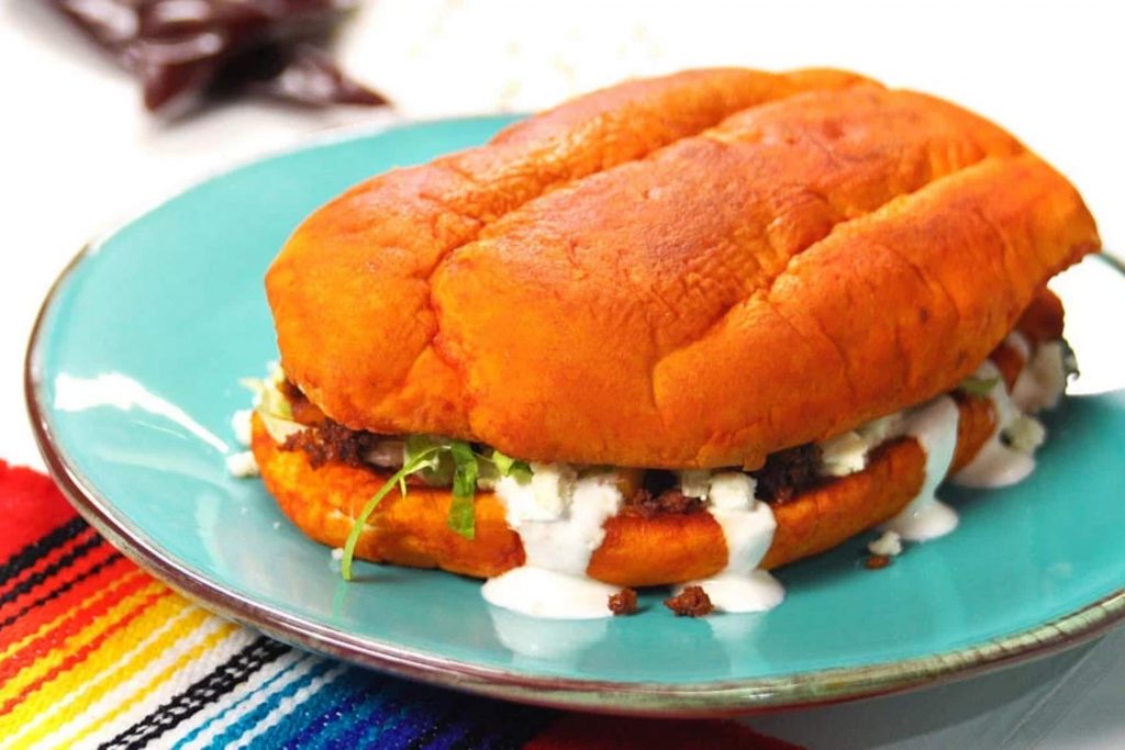 Un pambazo relleno de papa con chorizo, bañado en crema y queso. La nota te enseña la receta para preparar este clásico antojito de la Ciudad de México.