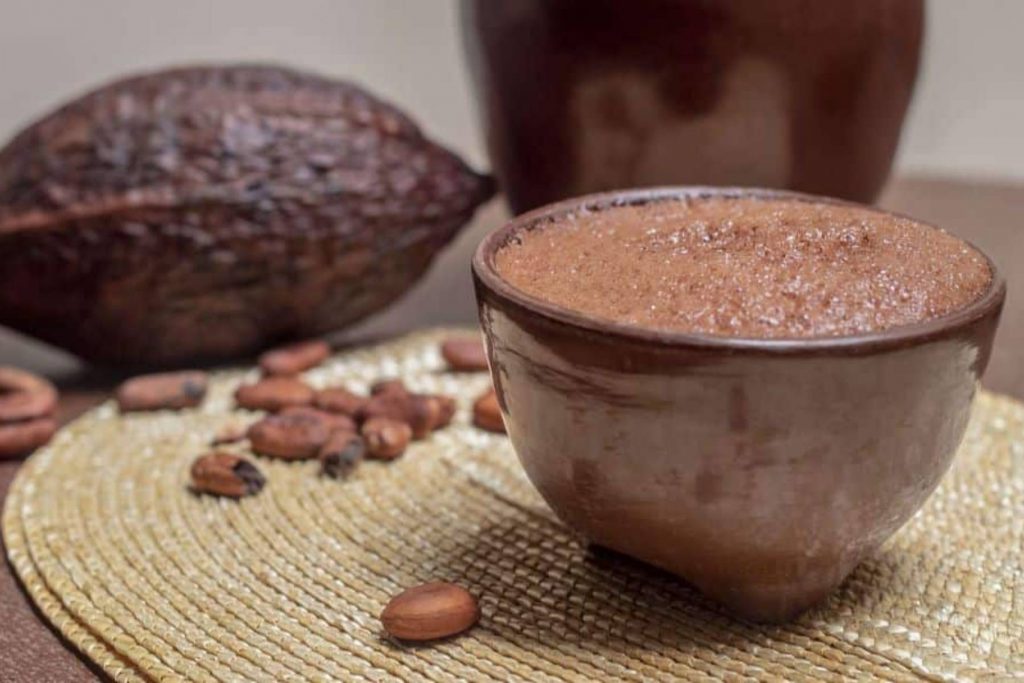 Una bebida de chocolate espumoso servida en una jícara de barro, como se consume tradicionalmente. La nota comparte recetas para preparar un auténtico chocolate caliente mexicano.