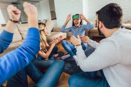 Un grupo de amigos jugando a "¿Quién soy?" o "Adivina el personaje". La nota da ideas de juegos de mesa y de palabras para la fiesta del Grito.