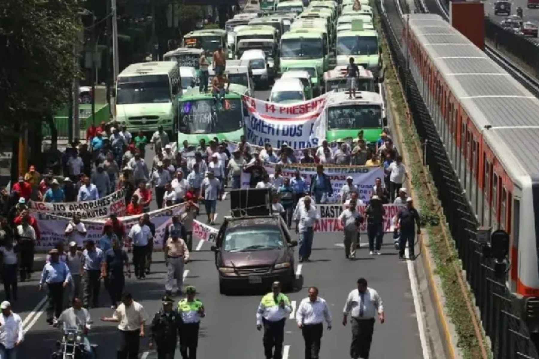 Una manifestación de transportistas bloqueando una avenida principal en la CDMX. La nota informa que la megamarcha planeada para este lunes fue suspendida.