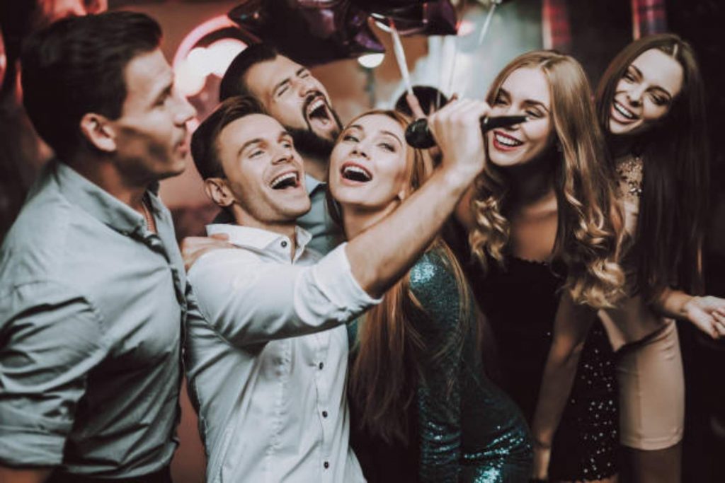 Un grupo de amigos cantando con sentimiento en un karaoke. La nota habla sobre el momento de la fiesta en que todos sacan al cantante que llevan dentro.